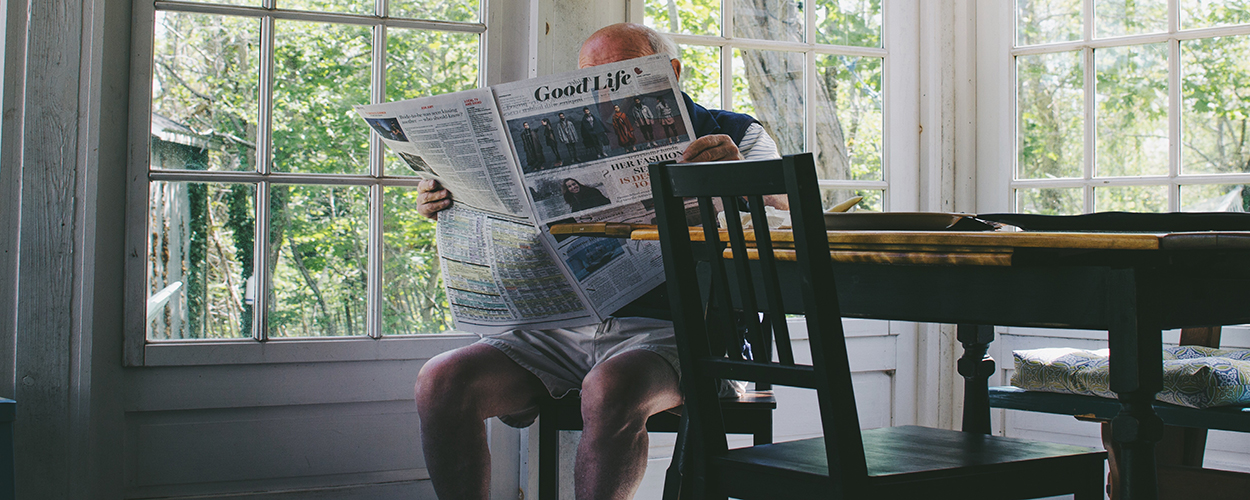 Elderly man reading the newspaper