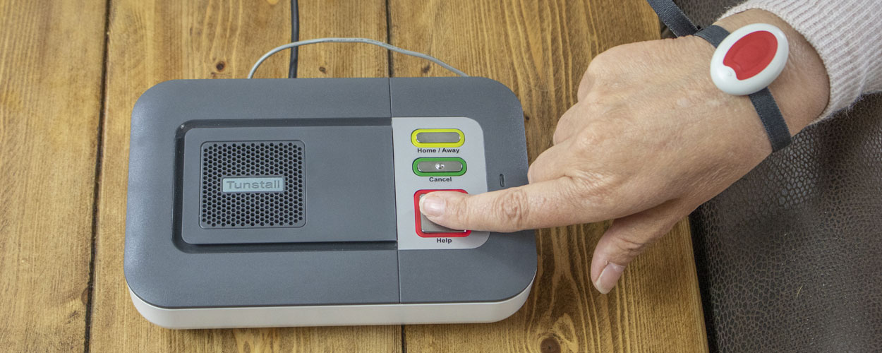 Elderly lady pressing the Careline Alarm whilst wearing the Careline pendant