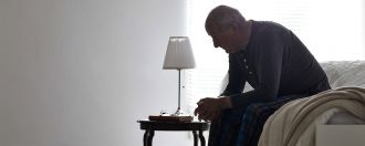 Elderly man sat on his bed