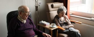 Elderly couple sat at home