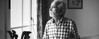 Elderly man looking out of the window