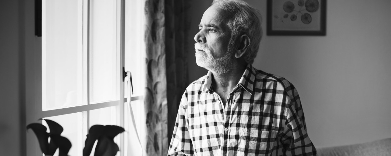 Elderly man looking out of the window