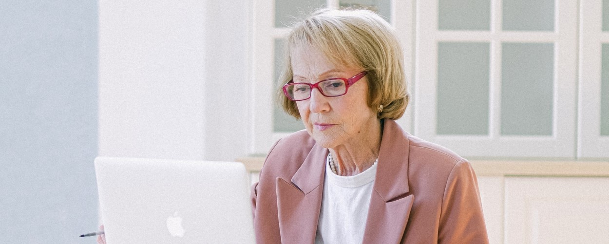 older woman reading on laptop