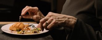 Elderly person eating dinner at a table