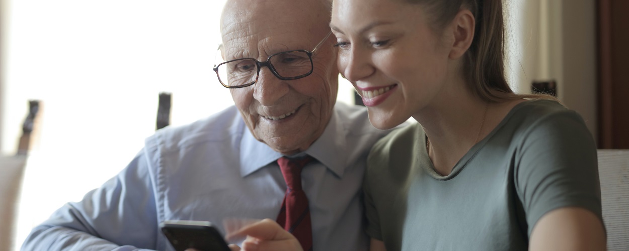 woman teaching older relative about online banking using a smartphone