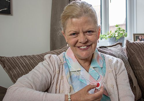 Elderly Lady pressing her Careline Pendant